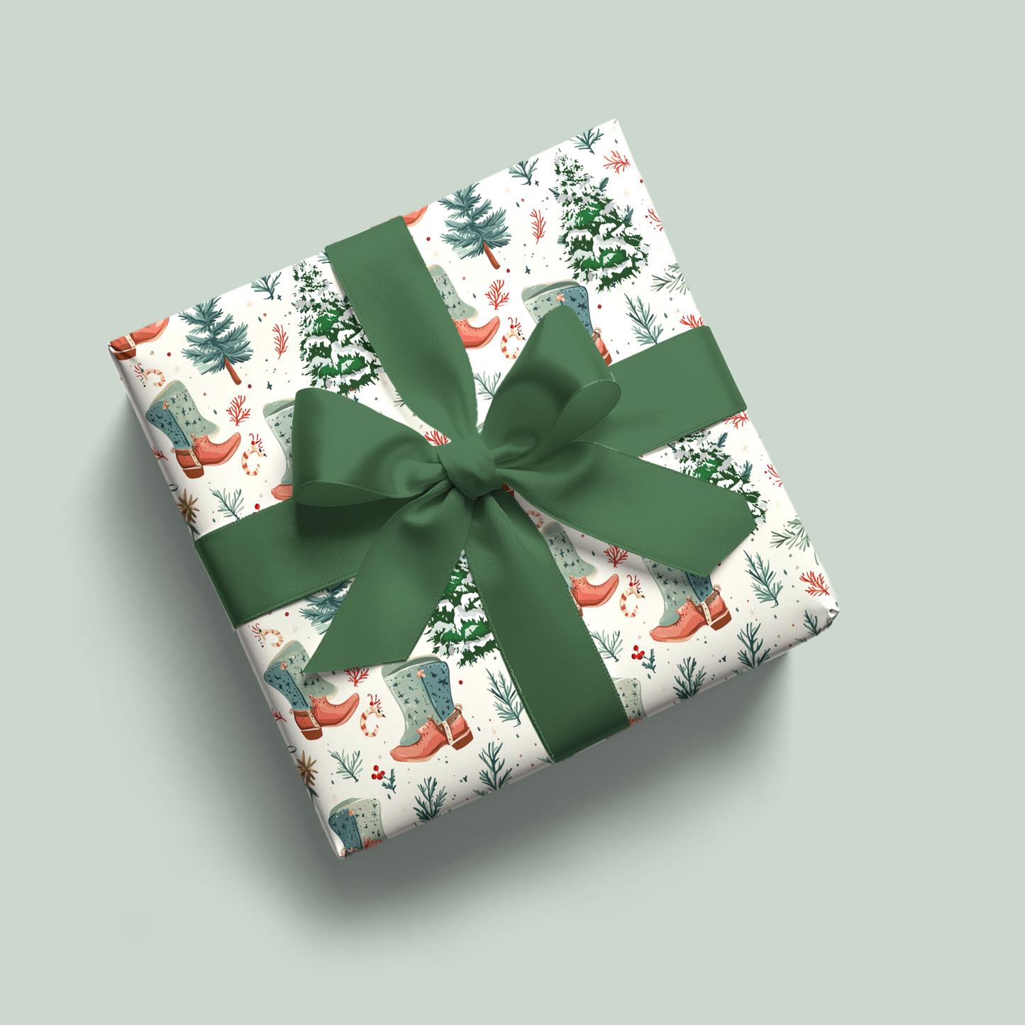 Gift box with Christmas-themed wrapping paper and a green ribbon on a light gray background