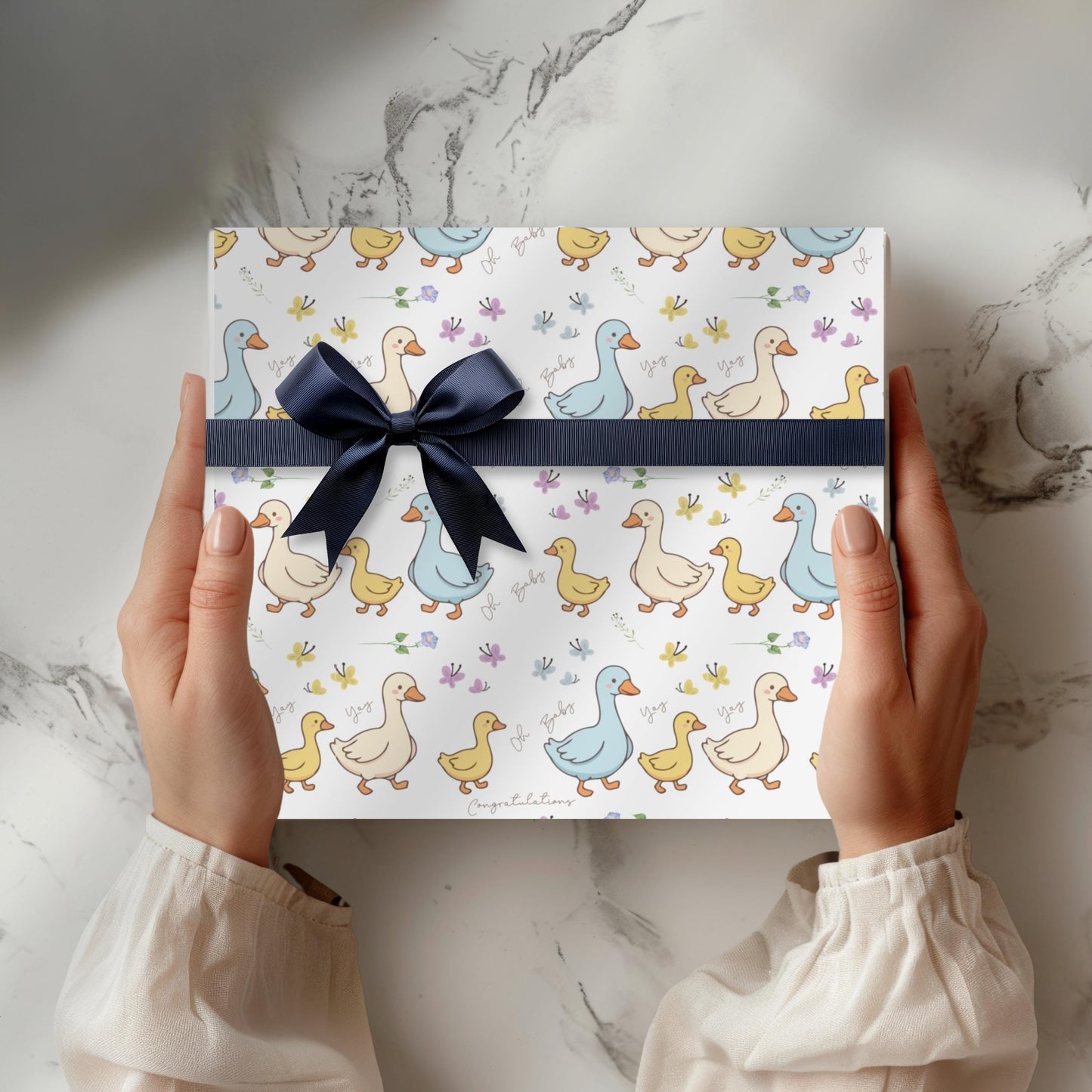 Cute duck baby shower wrapping paper with pastel ducklings and flowers wrapped around gift boxes