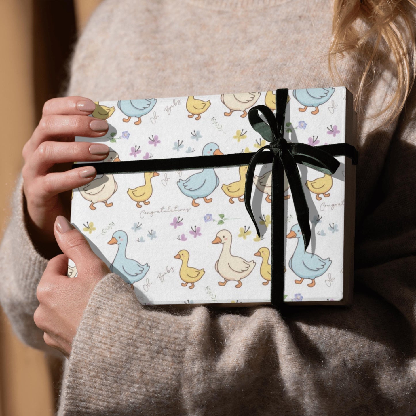 Cute duck baby shower wrapping paper with pastel ducklings and flowers wrapped around gift boxes