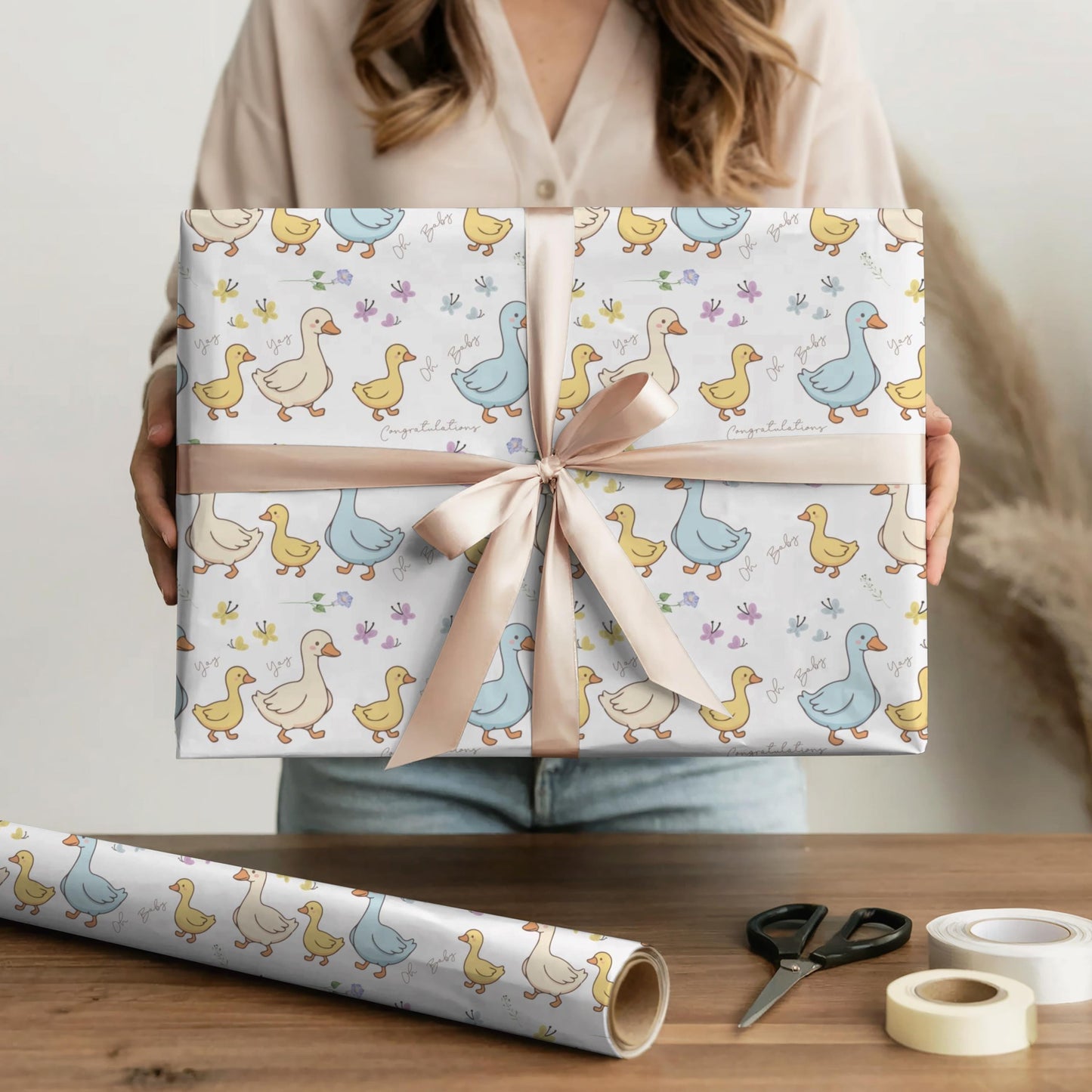 Cute duck baby shower wrapping paper with pastel ducklings and flowers wrapped around gift boxes